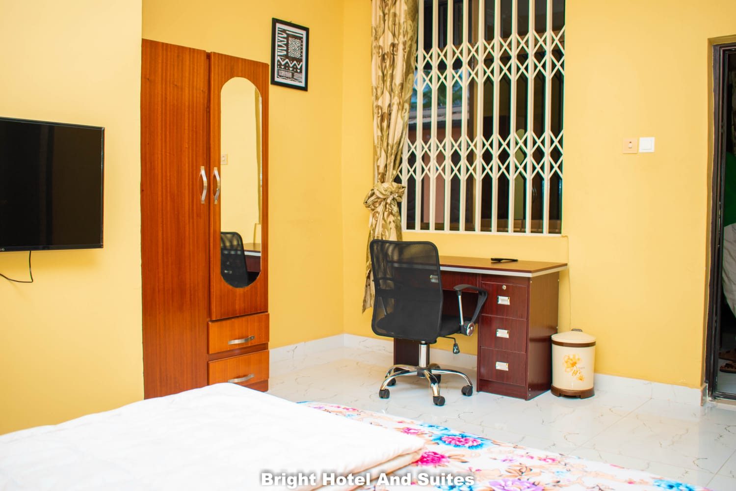 Air-conditioned guest room with television, wardrobe and work desk