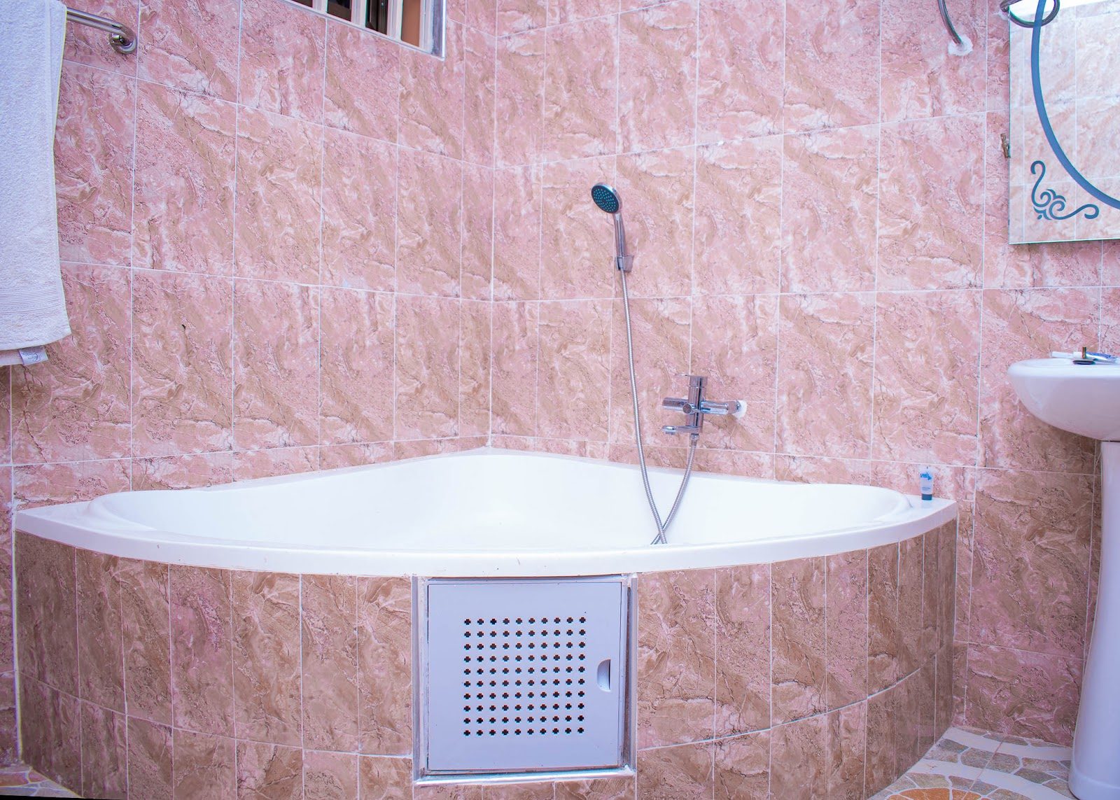 Private bathroom with corner bath at Bright Hotel and Suites