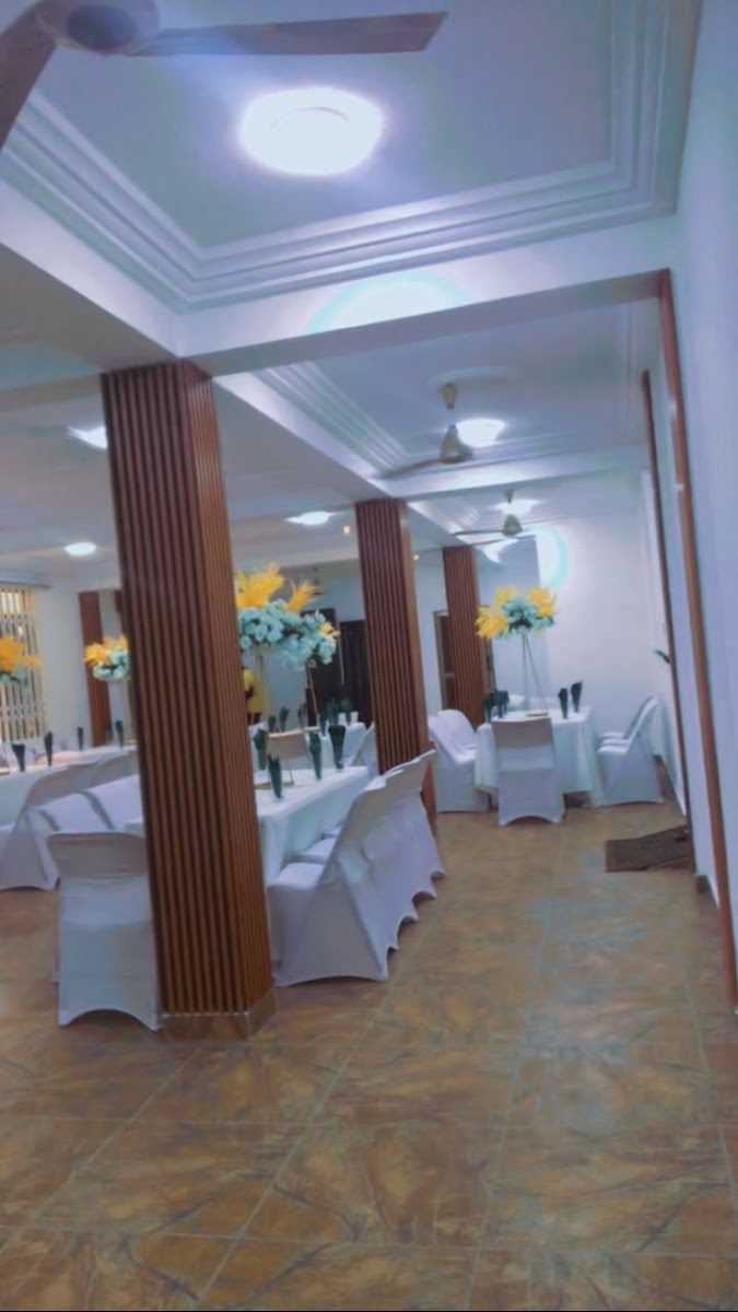 Indoor function space arranged with white-covered tables and flowers
